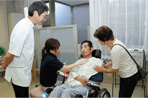 院内の患者を診て回る澤田石氏。この日は、言語障害のある患者の喉を、STがマッサージしていた。