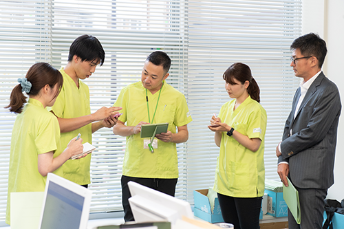 ふたば在宅クリニックの複数の医師および多職種がチームを組み、コミュニケーションを取っている様子